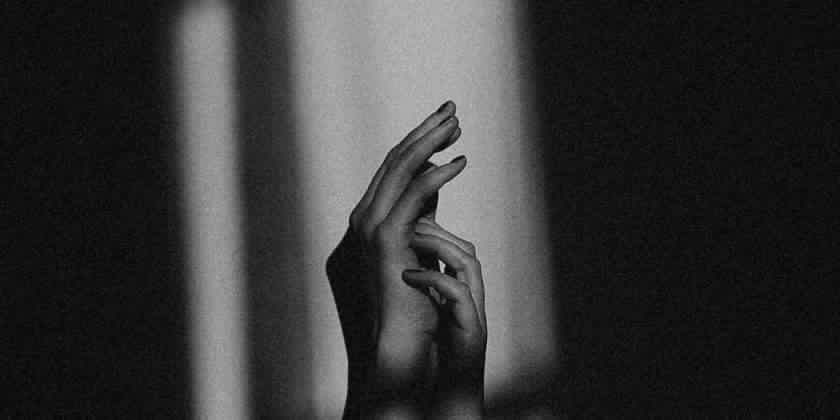 Dark image of two hands